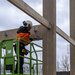 Bouwvakker op hoogwerker met hamer