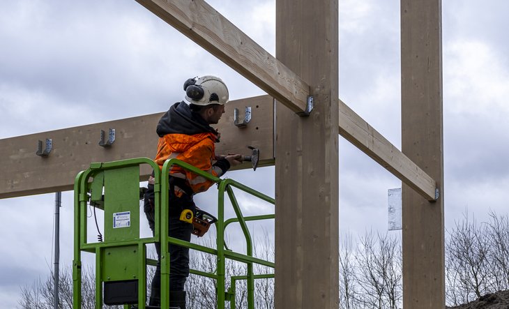 Bouwvakker op hoogwerker met hamer