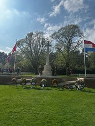 Monument met gelegde kransen en gehesen vlaggen