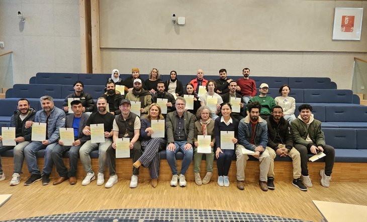 Wethouder en inburgeraars met certificaat