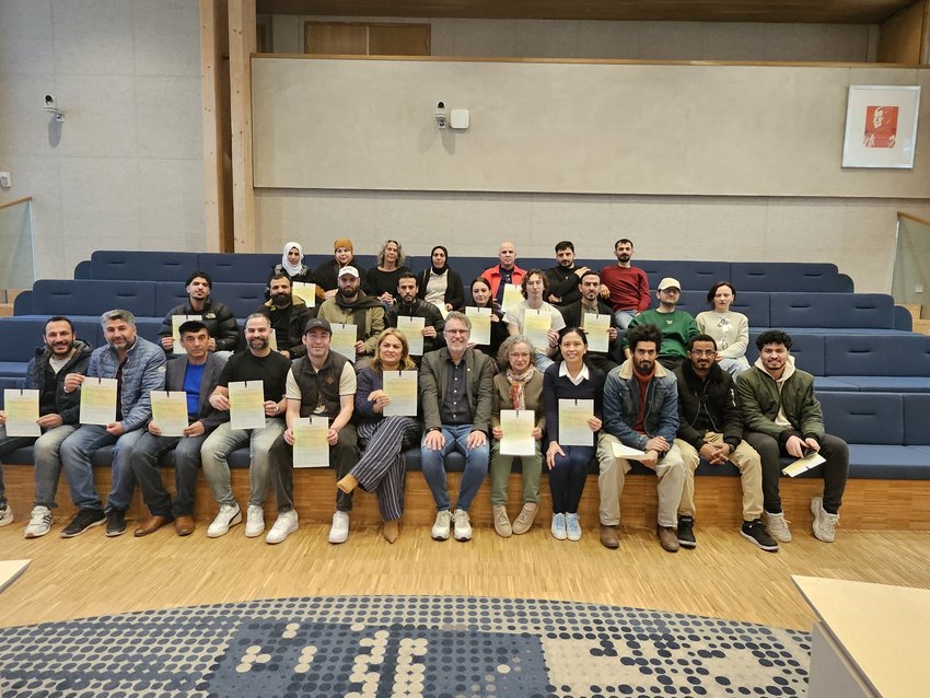 Wethouder en inburgeraars met certificaat