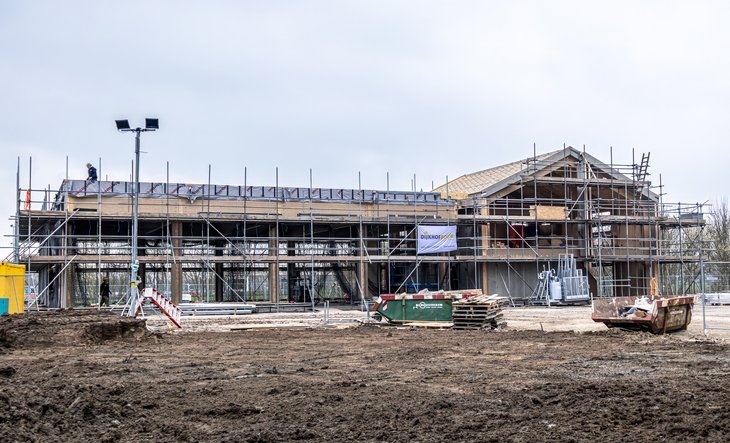 Voorkant van het gebouw en de garage in stijgers