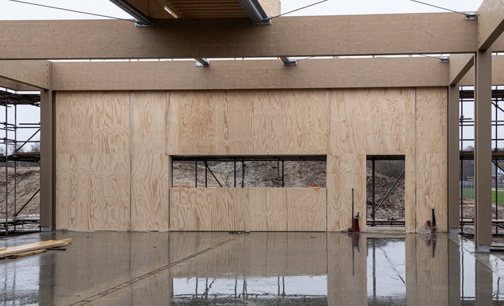 Geplaatste houten muur bij natte betonnen vloer
