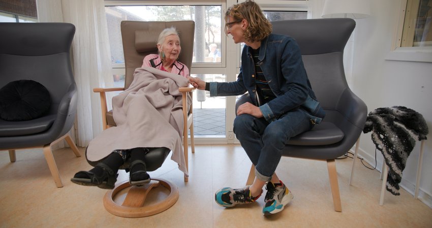 Teun Toebes stelt zich voor aan een oudere vrouw in een verzorgingshuis