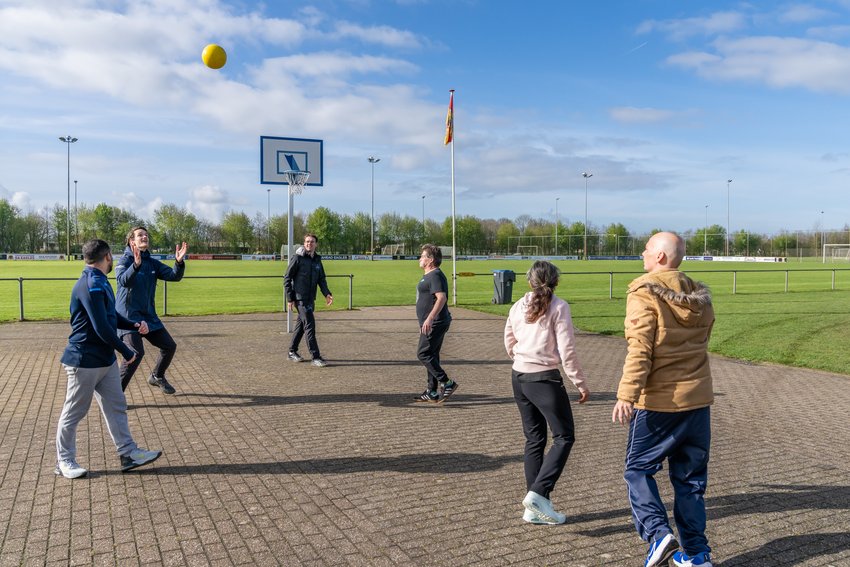 Groep mensen gooit een bal over