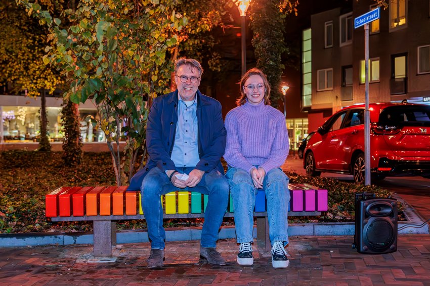 Wethouder Peter Wormskamp en Roos op het regenboogbankje