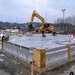 Betonnen fundering met op de achtergrond een graafmachine