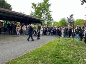 Wethouder en een leerling leggen een krans