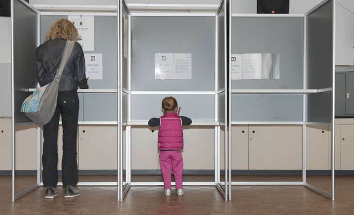 Moeder en kind in stemhokje