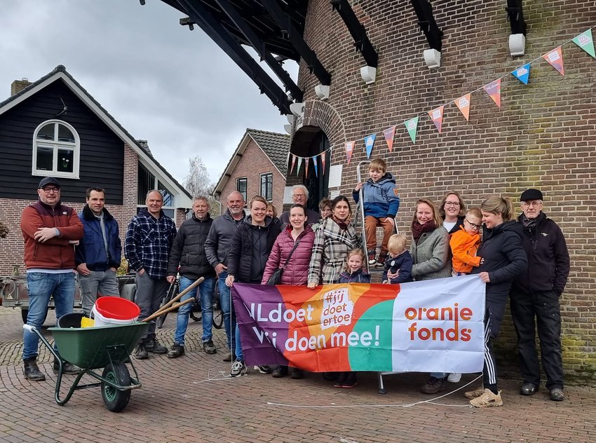 Vrijwilligers met spandoek NLdoet
