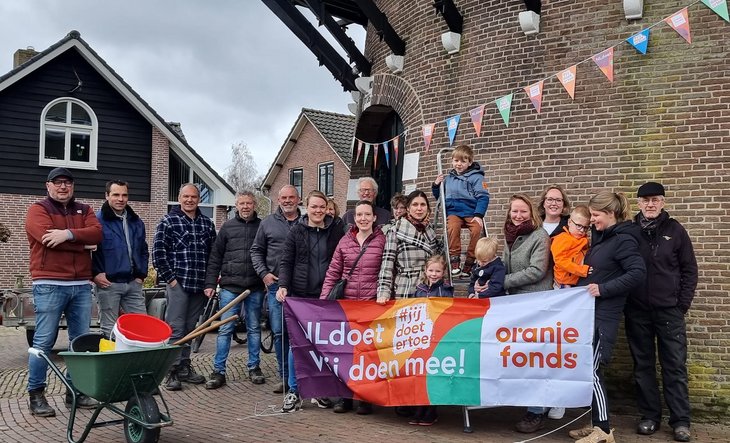 Vrijwilligers met spandoek NLdoet