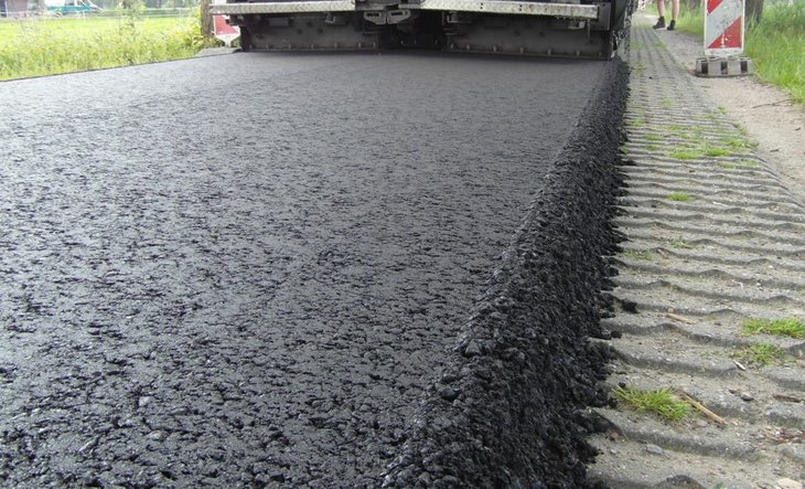 Aanbrengen van een nieuwe laag asfalt op een weg