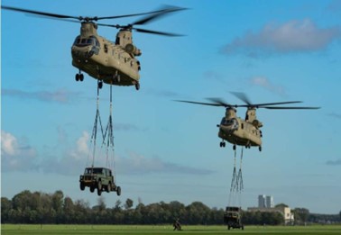 2 Chinook-helikopters in de lucht met auto's eronder